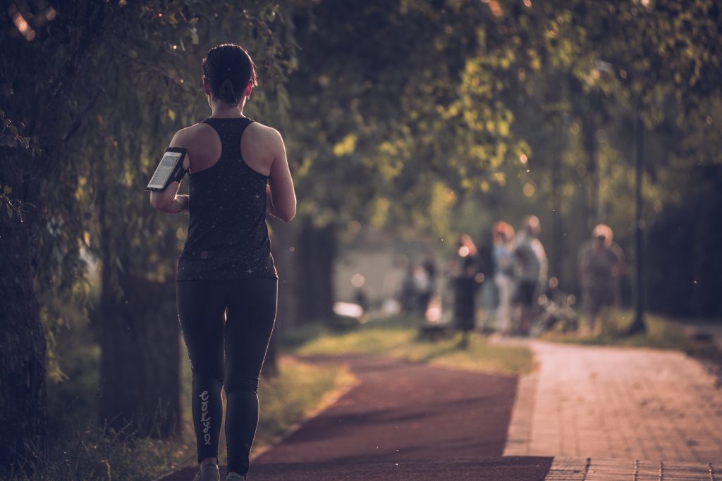 Mulher pratica exercício físico em parque ao entardecer