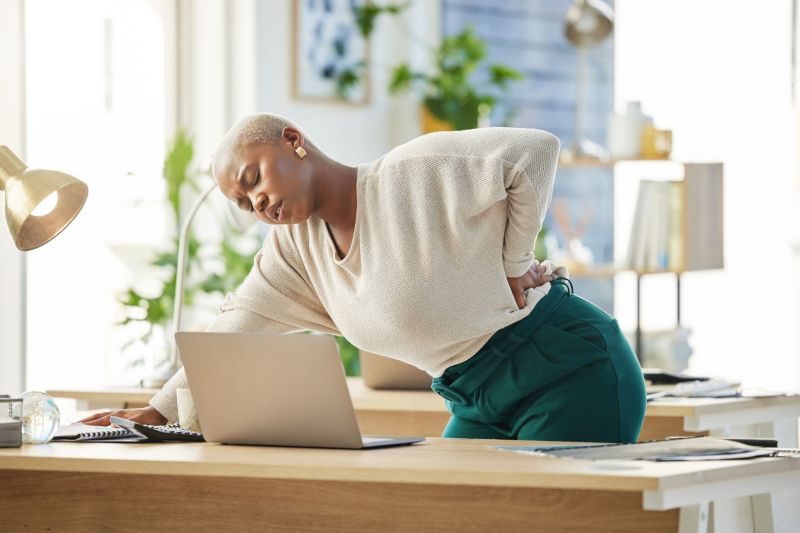 Work has gotten the best of her. Shot of a young businesswoman experiencing back pain
