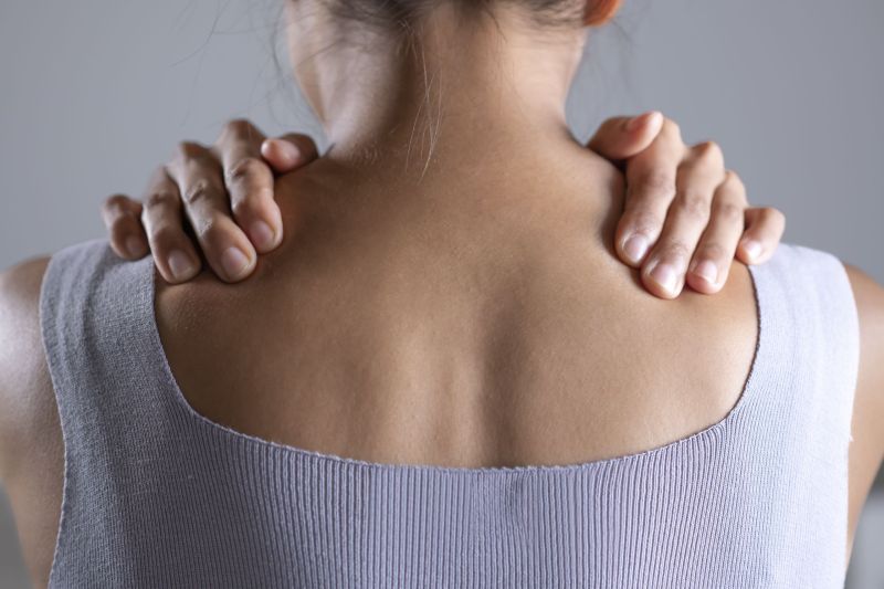 Asian woman has shoulder pain. Female holding painful shoulder with another hands. People with body-muscles problem, Healthcare And Medicine.